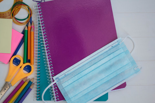 Mask on top of school supplies. Back to school during covid-19 pandemic, new normal concept