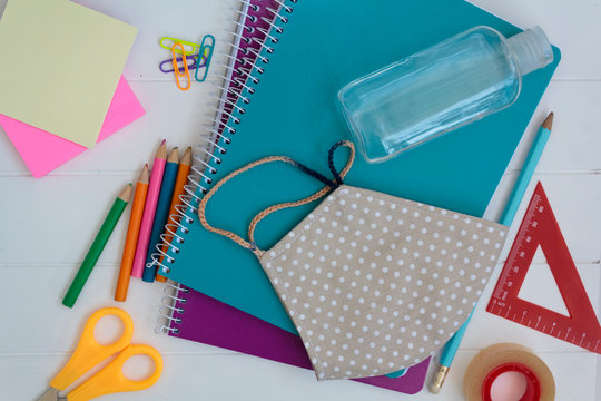 School supplies, cloth mask and hand sanitizer. Back to school during covid-19 pandemic, new normal concept