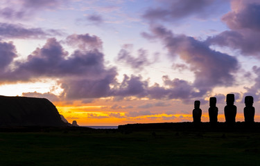 Silhouette of Moai statues at sunrise with long exposure and blur motion of clouds, Ahu Tongariki,...