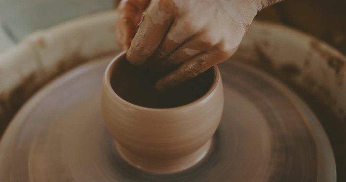Talented woman making clay bowl on pottery wheel, close up of hands and clay, handmade - Powered by Adobe