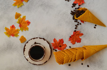 Cup of coffee and autumn leaves on the table indoor with copy space for text and design. Autumn...