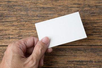 Hand holding Business card on a wood background