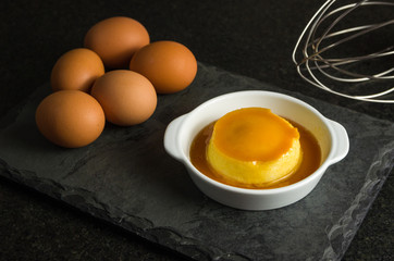 Traditional Brazilian dessert, milk pudding on dark background.