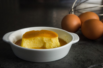 Traditional Brazilian dessert, milk pudding on dark background.