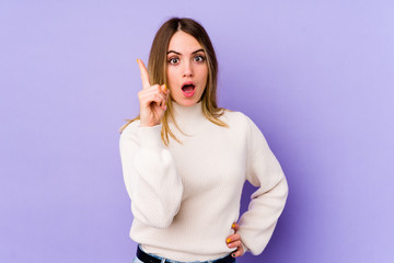Fototapeta premium Young caucasian woman isolated on purple background having an idea, inspiration concept.
