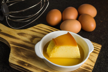 Traditional Brazilian dessert, milk pudding on dark background.