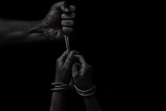 woman hands bound prisoner in room