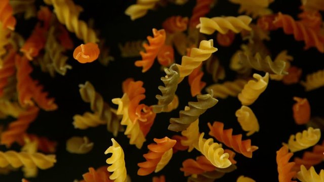 Super slow motion of flying uncooked italian pasta torti on black background. Filmed on high speed cinema camera, 1000 fps.