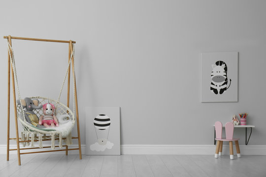 Stylish child's room interior with adorable paintings and hanging chair