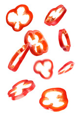 Red bell pepper slices falling on white background