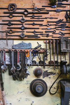 Set of different tools with various nut wrenches with wooden handle and wrench on brown board in studio