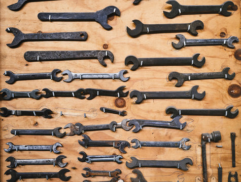 Set of different nut wrenches on brown board in studio