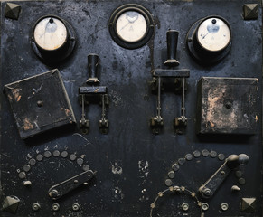 Aged metal control panel with switches and analogue gauges in craft workshop