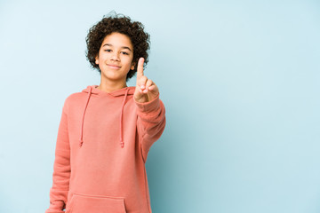 African american little boy isolated showing number one with finger.