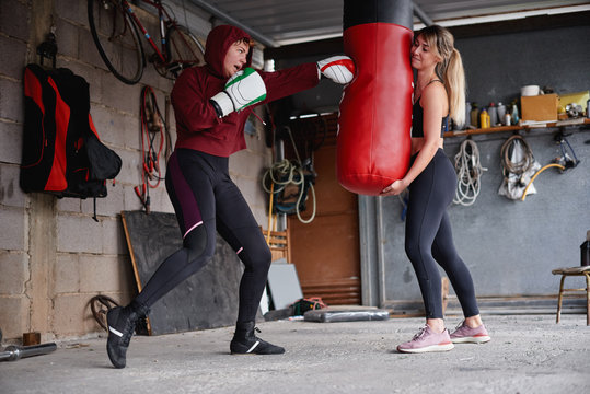 Sportswomen punching bag during boxing training