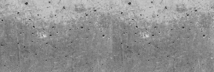 Obraz premium Texture of an aged and weathered grey concrete exterior wall. Plenty of holes around the surface. Conctruction and materials