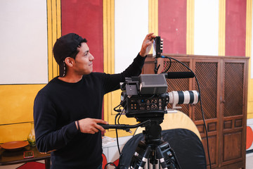 Side view of male video operator broadcasting live event and looking at display on camera