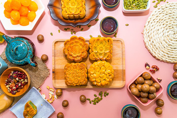 Flat lay mid autumn festival colorful food and drink on sweet pink background.