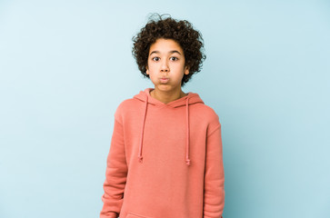 African american little boy isolated blows cheeks, has tired expression. Facial expression concept.