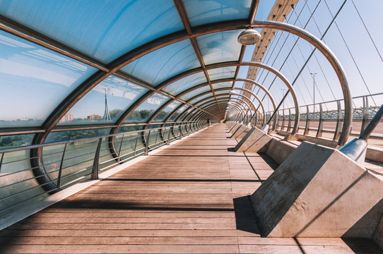 From inside view of modern half roofed walkway Third Millennium Bridge in shape of cone in Zaragoza Spain during clear day