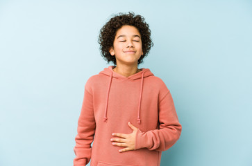 African american little boy isolated touches tummy, smiles gently, eating and satisfaction concept.