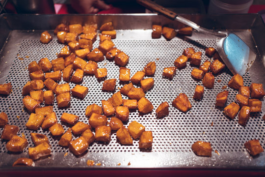 High angle of delicious sugar coated potato cubes scattered on metal counter in Zhubei Night Market