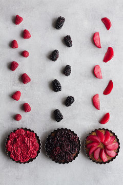 Top view of palatable pies with various ripe fruits and berries arranged in line on table