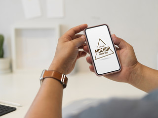 Cropped shot of male hands using mock up smartphone screen