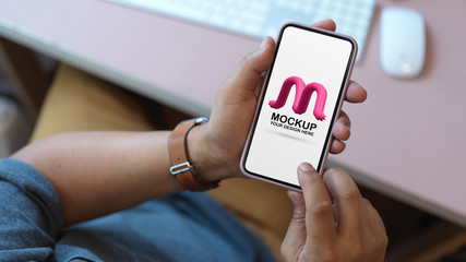 Overhead shot of male office worker using mock up smartphone