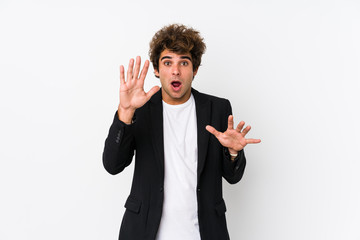 Young caucasian business man against a white background isolated being shocked due to an imminent...