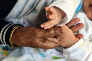 old man holding child's hands. selective focus