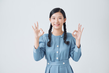 Asian woman show double OK hand sign and smile on white background