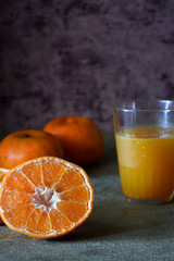orange fruit and fresh orange juice in the glass on drak white background