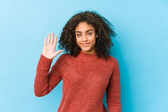 Young african american curly hair woman smiling cheerful showing number five with fingers.
