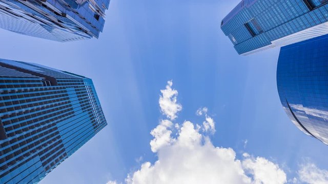 Footage 4k Timelapse, Looking up to Central Business District and downtown financial skyscraper buildings in Singapore with moving clouds and sun in the sky.