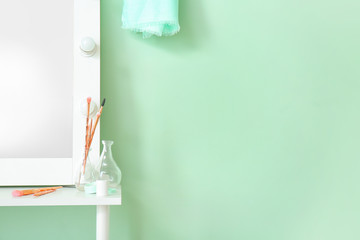 Dressing table near stylish mint wall in room