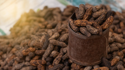 Raw, uncooked peanuts in a cup you can find at the bean market.