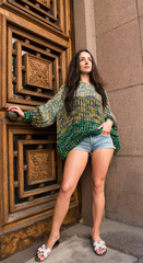 Young woman posing in trendy knitted sweater in the old city
