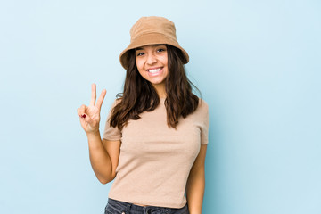 Young mixed race hispanic woman isolated joyful and carefree showing a peace symbol with fingers.