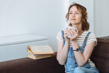 Happy young woman with cup of coffee or tea