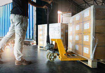 Workers Courier Using Hand Pallet Jack Unloading Package Boxes into Cargo Container. Delivery...