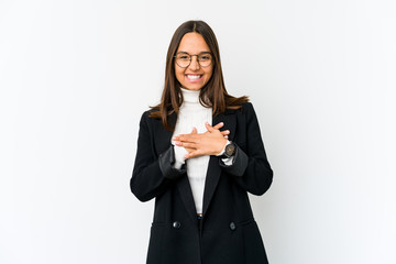 Young mixed race business woman isolated on white background laughs happily and has fun keeping hands on stomach.