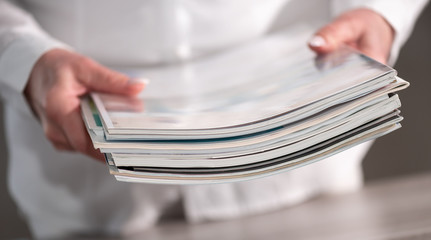 Female hands holding magazines
