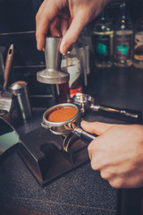 Barista pressing freshly grounded coffee into espresso mold