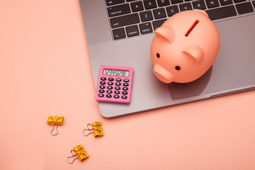 Business and finance desk workspace with high tech touchscreen laptop and pink theme accessories.