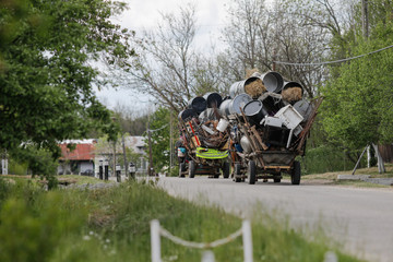 Obraz premium Carriages of Roma people filled with metal rubbish (which they sell later) on a countryside road.