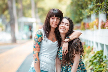 Obraz premium Summer vacation. Two happy young women embrace in the street. The concept of friendship and relationships