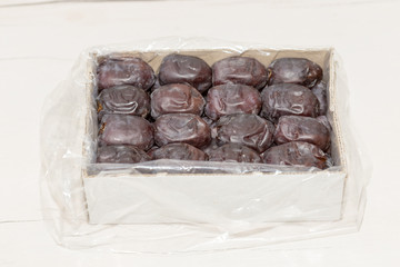 Oriental dates in a cardboard box on a white background. View from above.