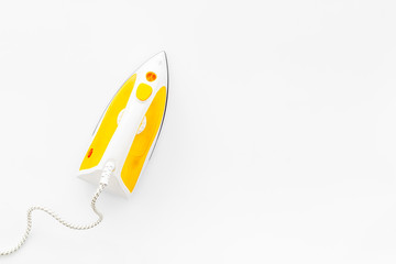 Yellow iron on ironing board. Top view, copy space