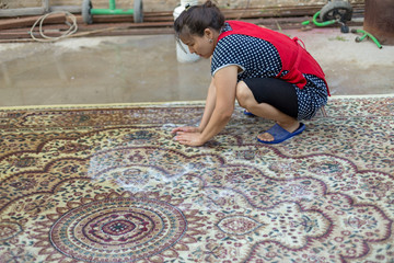 the girl washes the carpet